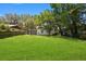 Sprawling backyard features lush green grass and mature trees, perfect for outdoor activities and relaxation at 1512 Hillside Dr, Tampa, FL 33610