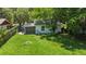 View of lush backyard with mature trees; charming firepit is perfect for entertaining and relaxation at 1512 Hillside Dr, Tampa, FL 33610