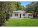 Charming single-story home with a well-manicured lawn and mature trees, creating a welcoming curb appeal at 1512 Hillside Dr, Tampa, FL 33610