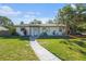 Charming home with a well-manicured lawn, walkway to the front door, and freshly painted exterior at 1601 Paloma Ln, Dunedin, FL 34698