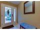 Inviting entryway with glass paneled door, bench, and decorative mirror at 163 Brent Cir, Oldsmar, FL 34677