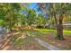 Spacious backyard with mature trees, a wooden fence, and a lush lawn, ideal for outdoor activities at 1752 42Nd S St, St Petersburg, FL 33711