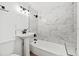 Updated bathroom with marble tile, modern fixtures, and a combination bathtub and shower with a rainfall showerhead at 1752 42Nd S St, St Petersburg, FL 33711