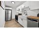 Modern kitchen features white cabinets, butcher block countertops, stainless steel appliances, and a farmhouse sink at 1752 42Nd S St, St Petersburg, FL 33711