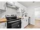 White kitchen features stainless steel appliances, subway tile backsplash, butcher block countertops, and modern black hardware at 1752 42Nd S St, St Petersburg, FL 33711