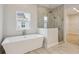 Modern bathroom features a standalone tub, tiled walk-in shower, and a view into the closet at 17555 Glistening Ct, Venice, FL 34293