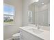 Bright bathroom featuring a white sink vanity with a view of the outdoors at 17555 Glistening Ct, Venice, FL 34293