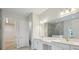 Bathroom featuring double sinks, quartz countertops, cabinetry, and a walk-in shower at 17555 Glistening Ct, Venice, FL 34293