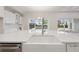 Large kitchen island with a farmhouse sink and stainless steel dishwasher at 17555 Glistening Ct, Venice, FL 34293