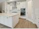 Modern kitchen with white cabinets, stainless steel appliances and a center island with white countertop at 17555 Glistening Ct, Venice, FL 34293