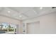 Bright open living room featuring a coffered ceiling and sliding glass doors at 17555 Glistening Ct, Venice, FL 34293