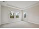 Spacious bedroom with tray ceilings, plush carpeting, and bright windows with views of the backyard at 17555 Glistening Ct, Venice, FL 34293
