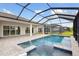 Backyard with a screened-in pool and spa, surrounded by brick pavers and lush landscaping at 17555 Glistening Ct, Venice, FL 34293