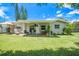 View of backyard with covered patio, outdoor seating, and manicured lawn at 1857 N Belleair N Rd, Clearwater, FL 33764