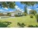 Exterior showcasing a well-maintained yard, carport, and a neatly painted home with dark shutters at 1857 N Belleair N Rd, Clearwater, FL 33764