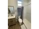 Well-lit bathroom featuring a walk-in shower, a toilet, and a vanity with a sink and mirror at 1935 Oxnard Ct, Tampa, FL 33612