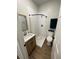 A bright bathroom with a modern vanity, a walk-in shower with stylish tile, and wood-look flooring at 1935 Oxnard Ct, Tampa, FL 33612