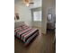 Cozy bedroom with a striped bed, a nightstand, and a doorway leading to an ensuite bathroom at 1935 Oxnard Ct, Tampa, FL 33612