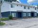 View of a two-story townhome building with designated parking spaces and landscaped entryways at 1935 Oxnard Ct, Tampa, FL 33612