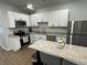 The kitchen showcases new white cabinets, stainless steel appliances, and stylish granite countertops at 1935 Oxnard Ct, Tampa, FL 33612