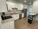 Modern kitchen featuring white cabinets, stainless steel appliances, and granite countertops, plus laundry area at 1935 Oxnard Ct, Tampa, FL 33612