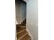 A home staircase featuring light wood stairs, white risers, and a silver handrail against a light gray wall at 1935 Oxnard Ct, Tampa, FL 33612