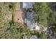 Aerial view of a home with an outdoor seating area in the backyard, lush landscaping, and mature trees at 1949 Kings Hwy, Clearwater, FL 33755