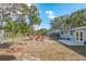 An expansive yard featuring an outdoor seating area, a concrete patio, and mature palm trees at 1949 Kings Hwy, Clearwater, FL 33755