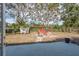 Spacious backyard featuring outdoor seating, mature trees, and a well-maintained lawn at 1949 Kings Hwy, Clearwater, FL 33755