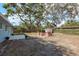 A home's spacious backyard that has an outdoor seating area, a concrete patio, and mature trees at 1949 Kings Hwy, Clearwater, FL 33755