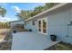 Back of the home featuring a concrete patio with double doors that lead to the home's interior at 1949 Kings Hwy, Clearwater, FL 33755
