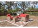 Outdoor patio with a red cushioned wicker seating set and a checkerboard style brick-paver pad at 1949 Kings Hwy, Clearwater, FL 33755