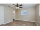 Cozy bedroom featuring wood-look floors, ceiling fan, and ensuite bathroom at 1949 Kings Hwy, Clearwater, FL 33755