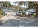Single-story home boasting an attached two-car garage, blue and grey paint scheme, and mature landscaping at 1949 Kings Hwy, Clearwater, FL 33755