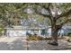 Charming single-story home featuring a well-manicured lawn, mature trees, and a one car garage at 1949 Kings Hwy, Clearwater, FL 33755