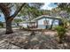 Charming single-story home featuring a well-manicured lawn, mature trees, and a one car garage at 1949 Kings Hwy, Clearwater, FL 33755