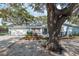 Charming single-story home featuring a well-manicured lawn, mature trees, and a one car garage at 1949 Kings Hwy, Clearwater, FL 33755