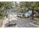 Charming single-story home featuring a well-manicured lawn, mature trees, and a one car garage at 1949 Kings Hwy, Clearwater, FL 33755
