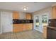 Bright kitchen showcasing wood cabinets, tiled floors, and sliding glass doors that open to the outdoor space at 1949 Kings Hwy, Clearwater, FL 33755