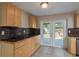 Bright kitchen with wooden cabinets, dark countertops, and access to the backyard through glass doors at 1949 Kings Hwy, Clearwater, FL 33755