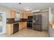 Well-equipped kitchen featuring stainless steel appliances, tiled flooring, wooden cabinets, and plenty of counter space at 1949 Kings Hwy, Clearwater, FL 33755