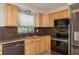 Functional kitchen boasting stainless steel appliances, tiled floor, wood cabinetry, and a large window for natural light at 1949 Kings Hwy, Clearwater, FL 33755