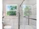 Elegant bathroom featuring sleek black and white tiles, glass shower doors, and a bright window at 201 83Rd N Ave, St Petersburg, FL 33702