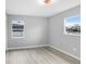Bright bedroom features wood floors, neutral walls, and ample natural light from two windows at 201 83Rd N Ave, St Petersburg, FL 33702