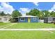 Charming blue home featuring a vibrant yellow door, well-manicured lawn, and inviting curb appeal at 201 83Rd N Ave, St Petersburg, FL 33702