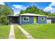 Comfortable home with carport, highlighted by its yellow door, and verdant green lawn at 201 83Rd N Ave, St Petersburg, FL 33702