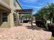 Expansive brick patio with wooden pergola, mature palm trees, and lush backyard with privacy fence at 20101 Oakflower Ave, Tampa, FL 33647
