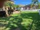 Green backyard featuring lush lawn and landscaping with a white picket fence at 20101 Oakflower Ave, Tampa, FL 33647