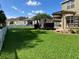 Green backyard featuring lush lawn and landscaping with a white picket fence at 20101 Oakflower Ave, Tampa, FL 33647