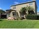 Backyard with a green lawn, pergola, lush landscaping, and two-story home at 20101 Oakflower Ave, Tampa, FL 33647